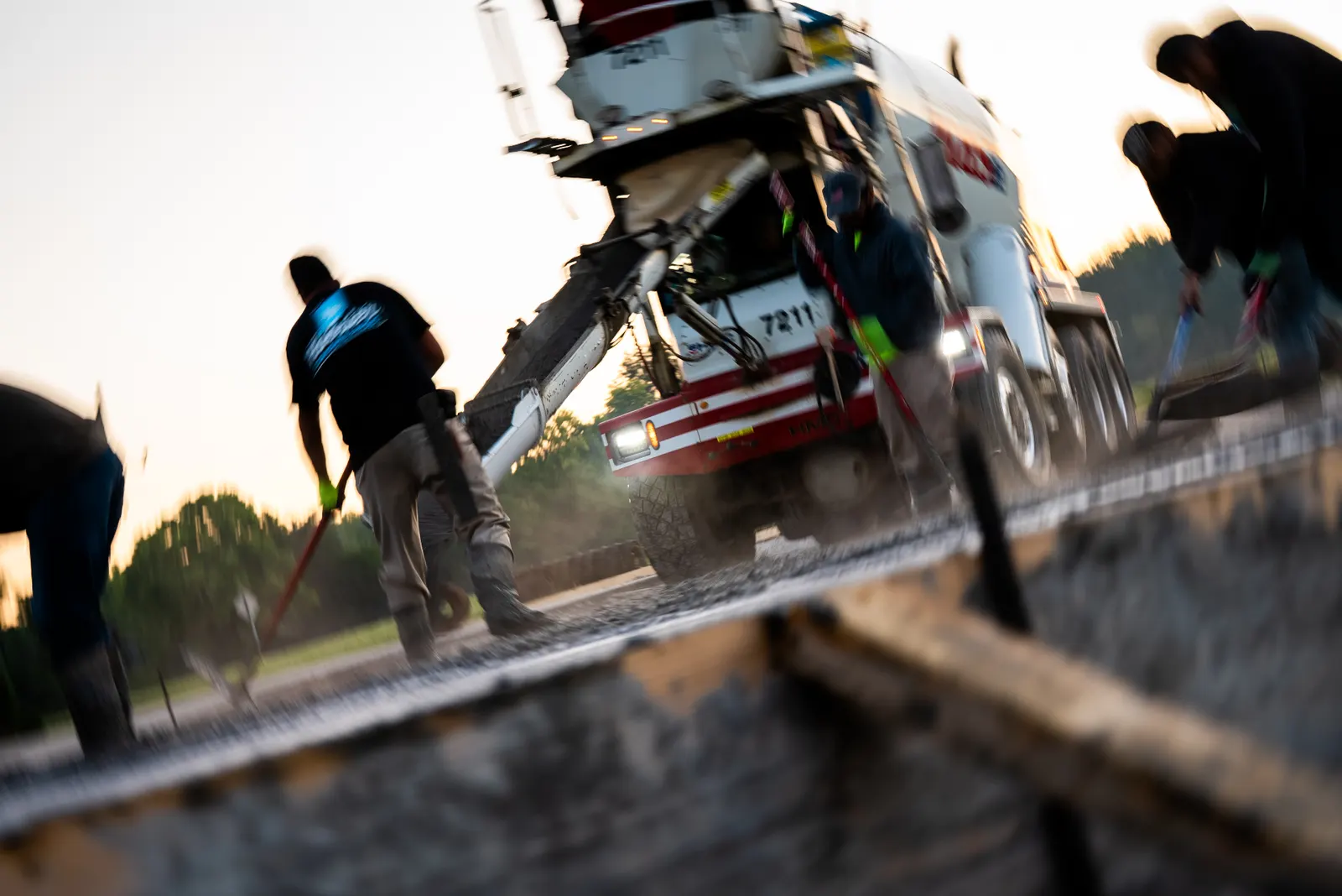 Concrete mixer truck delivering at sunrise